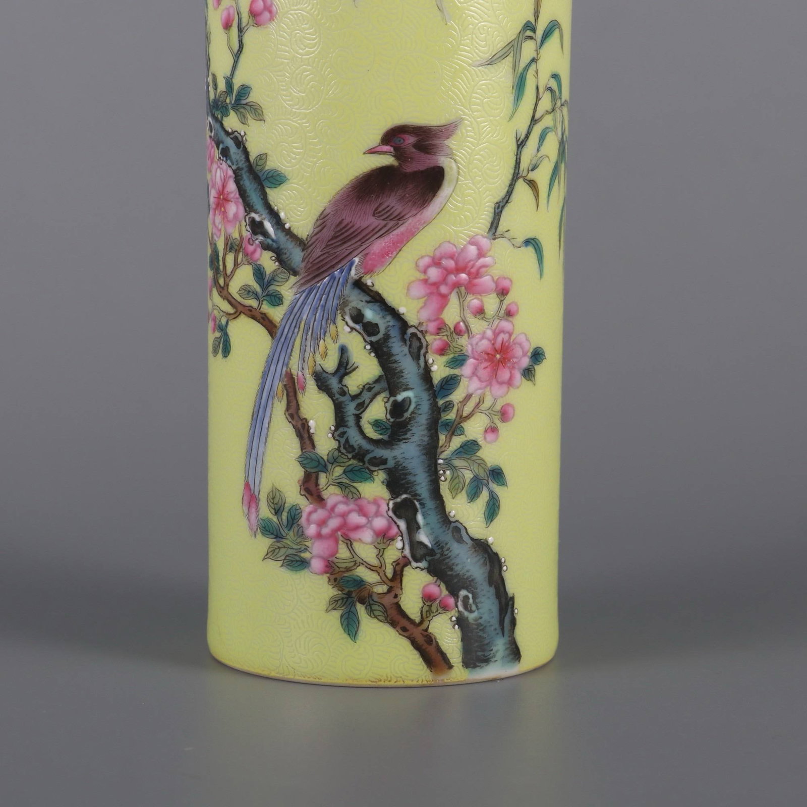A Qing Dynasty (Yongzheng period): A Qing Dynasty (Yongzheng period) yellow-ground famille rose brush pot with floral and bird design. Dimensions: Height 15 cm, Mouth Diameter 5.6 cm.