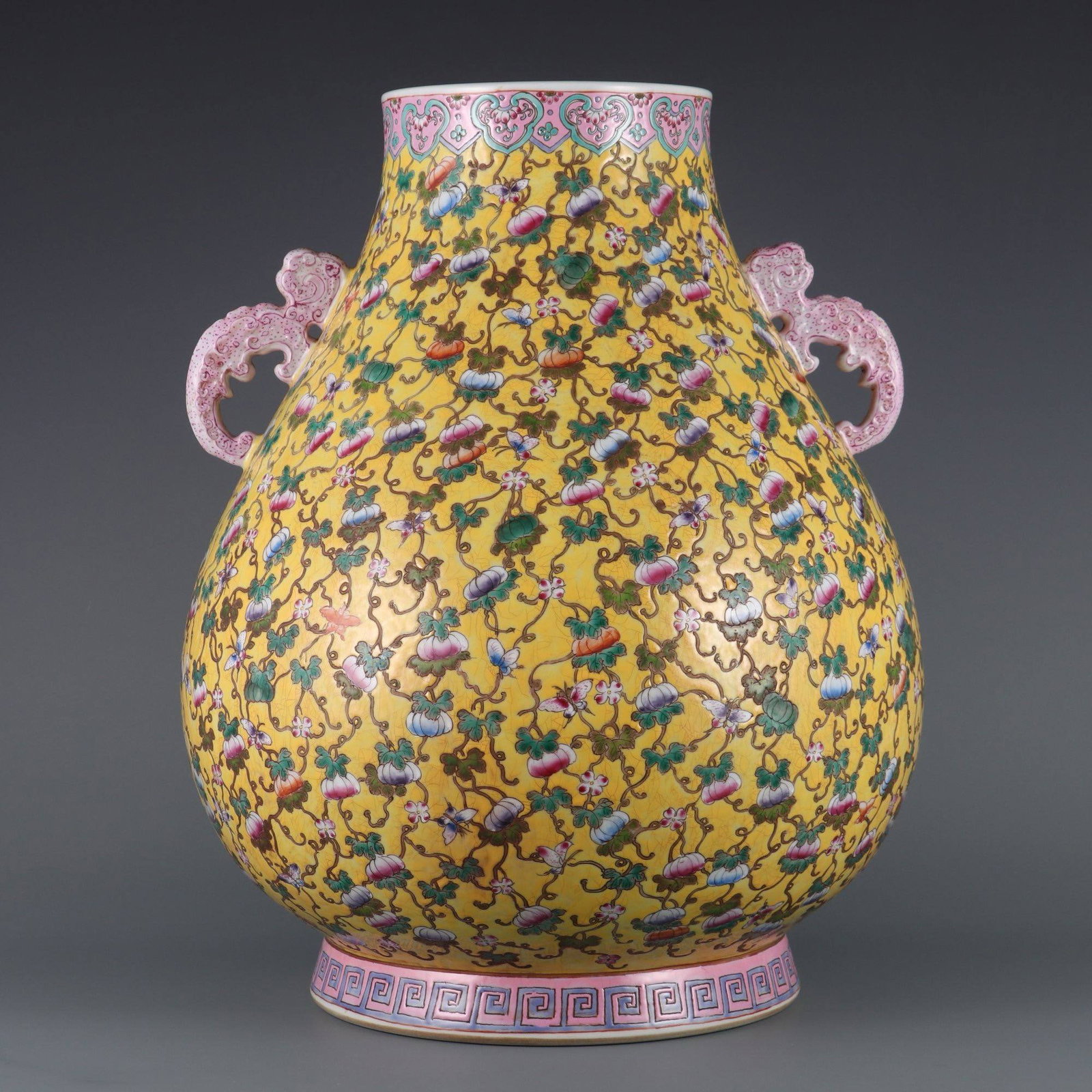 A Qing Dynasty Qianlong period (1736-1745): A Qing Dynasty Qianlong period (1736-1745) yellow-ground famille rose vase with melon and butterfly motifs and auspicious handles. Dimensions: Height 45.6 cm, Mouth Diameter 16.5 cm.