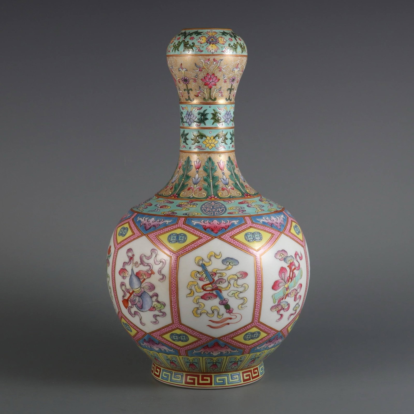 A Qing Dynasty Qianlong period famille rose garlic-shaped vase: A Qing Dynasty Qianlong period famille rose garlic-shaped vase with gilt-painted floral design and hidden Eight Immortals motif. Dimensions: Height 32.8 cm, Belly diameter 18.5 cm, Mouth diameter 4.8 
