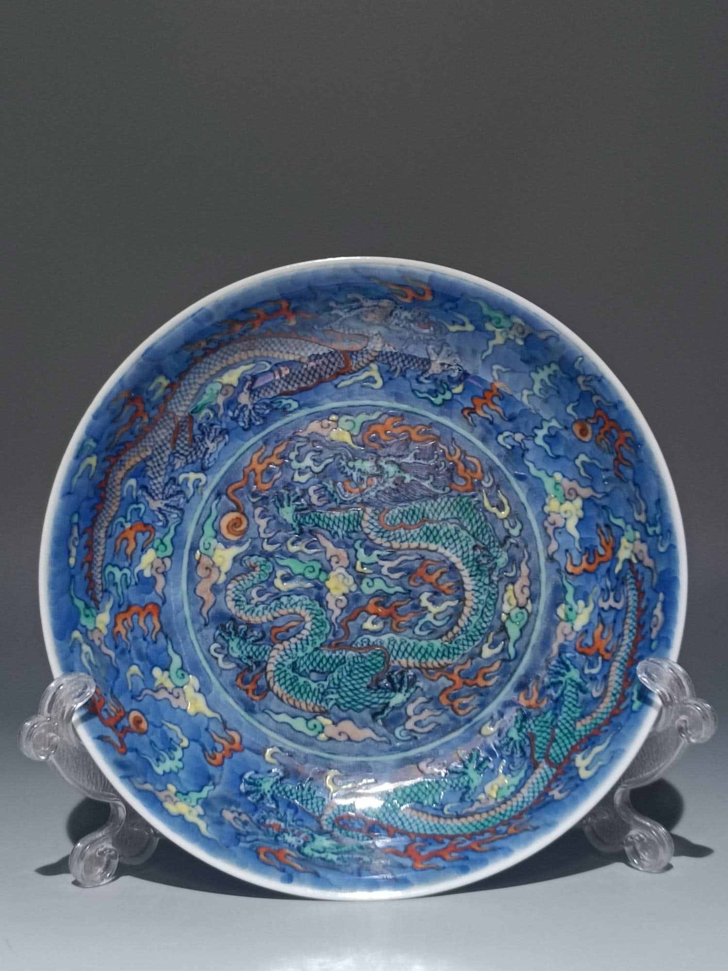 A blue and white porcelain dish: A blue and white porcelain dish with five dragons amidst clouds and waves, bearing the mark of the Kangxi period of the Qing dynasty. Diameter: 17cm; Height: 3.6cm.
