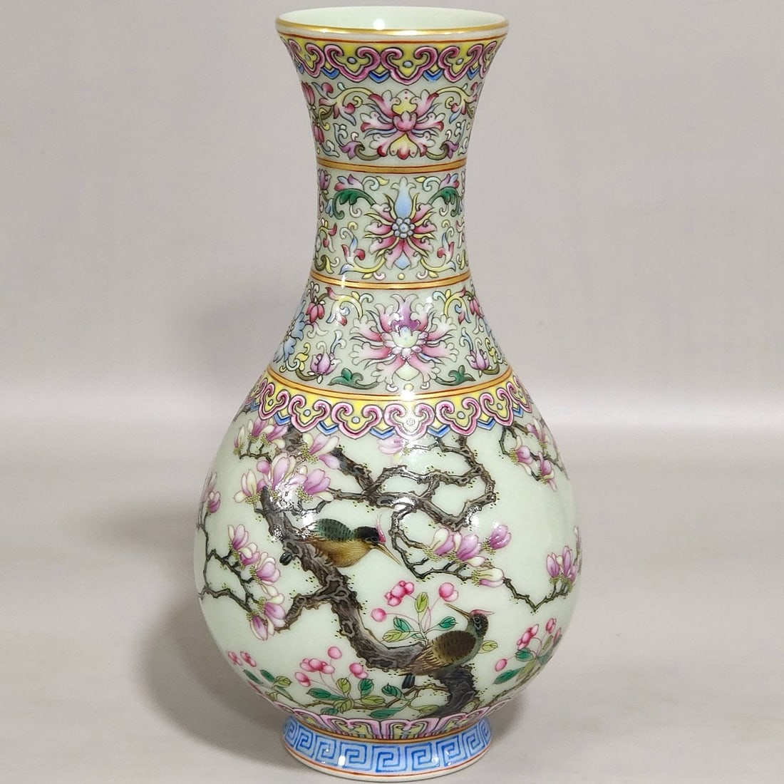 A celadon-glazed vase with magnolia and bird motifs and an inscription: A celadon-glazed vase with magnolia and bird motifs and an inscription by the poet Yuhuchun style, dating from the Qianlong period of the Qing dynasty. 15.5 cm high, 8 cm in diameter at the mouth.