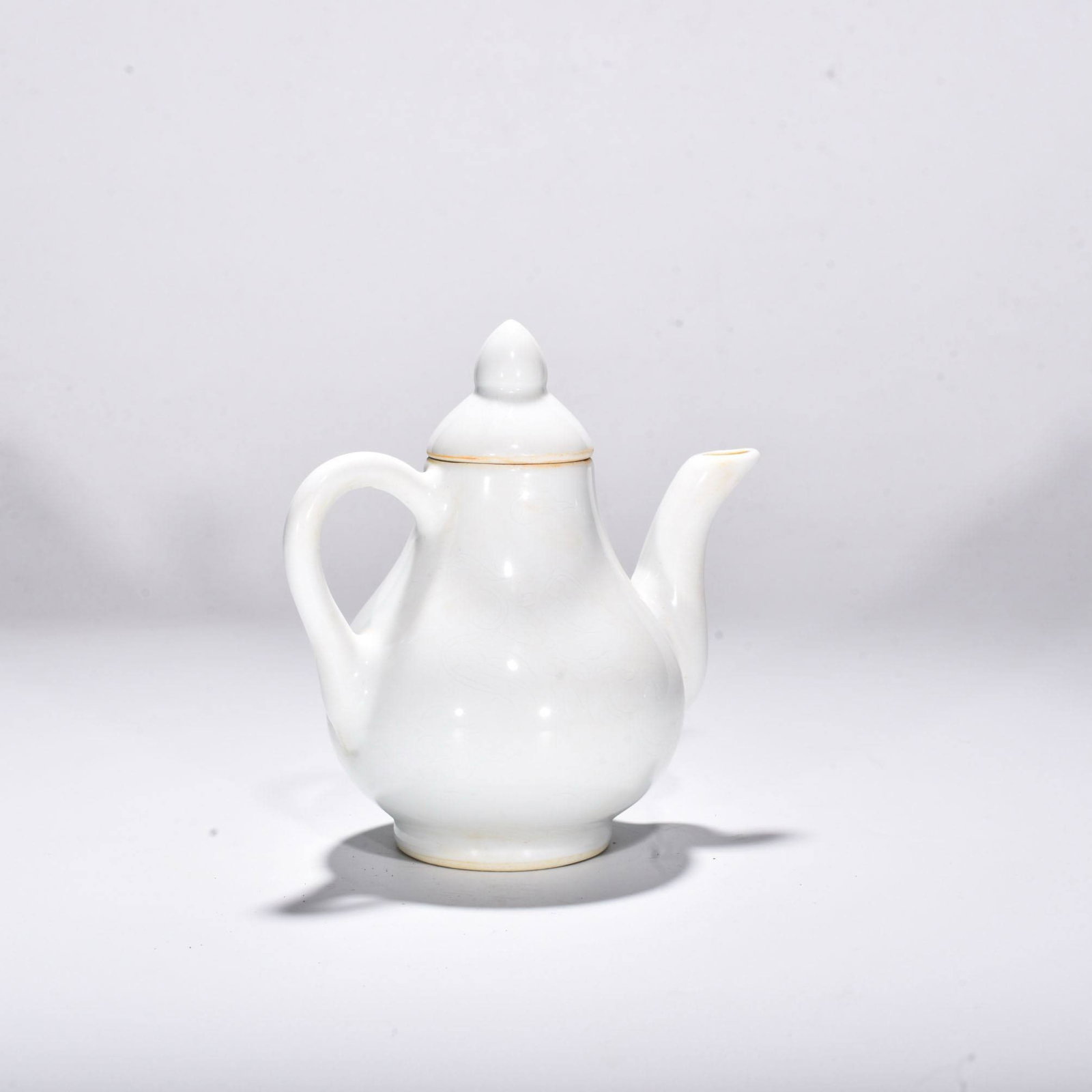 Ming Yongle period sweet white glaze pear-shaped ewer: Ming Yongle period sweet white glaze pear-shaped ewer with incised dragon and phoenix design. Height 15 cm, Width 15 cm.