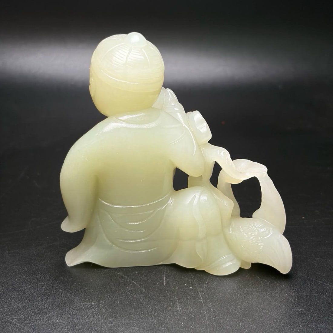 Hetian jade carving, "Xi Zhi Loves Geese: Hetian jade carving, "Xi Zhi Loves Geese," depicts a child holding a ruyi (a traditional Chinese scepter symbolizing good fortune) and accompanied by geese. The overall design conveys auspiciousness, 