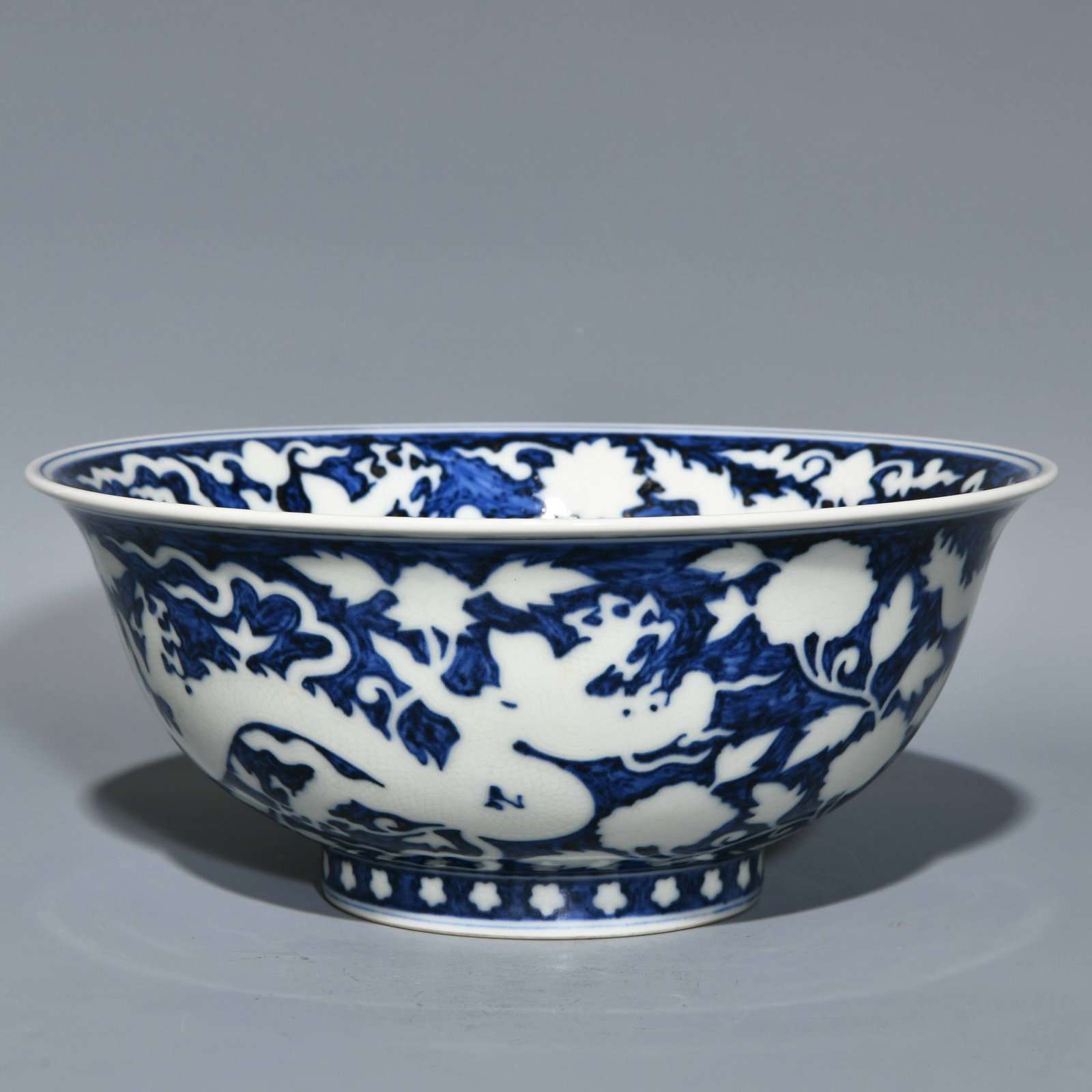 A Ming Dynasty Xuande period blue and white porcelain bowl with a dragon and floral design: A Ming Dynasty Xuande period blue and white porcelain bowl with a dragon and floral design, 9.5cm high and 22.3cm in diameter.