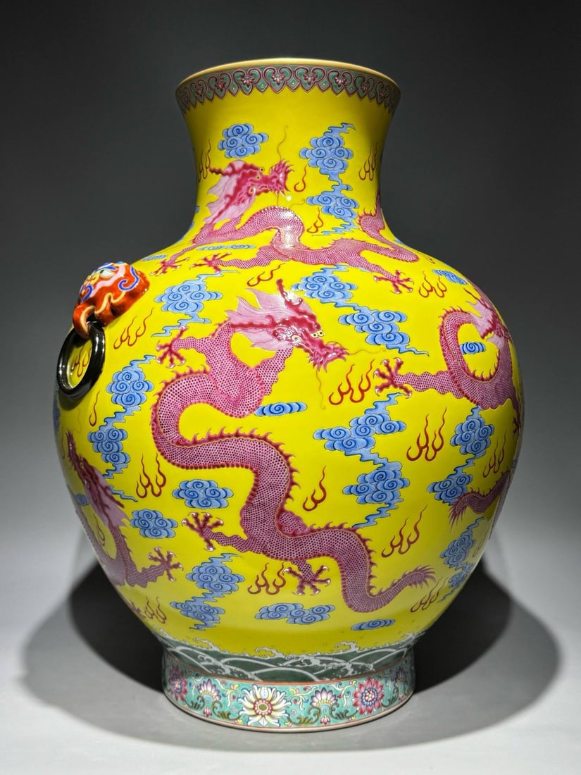 A Qing Dynasty Qianlong period (1736-1745): A Qing Dynasty Qianlong period (1736-1745) famille rose enamel vase with a yellow ground and ruby-red handles, featuring nine dragons and animal-shaped ornaments. Height: 50.5cm Width: 40cm