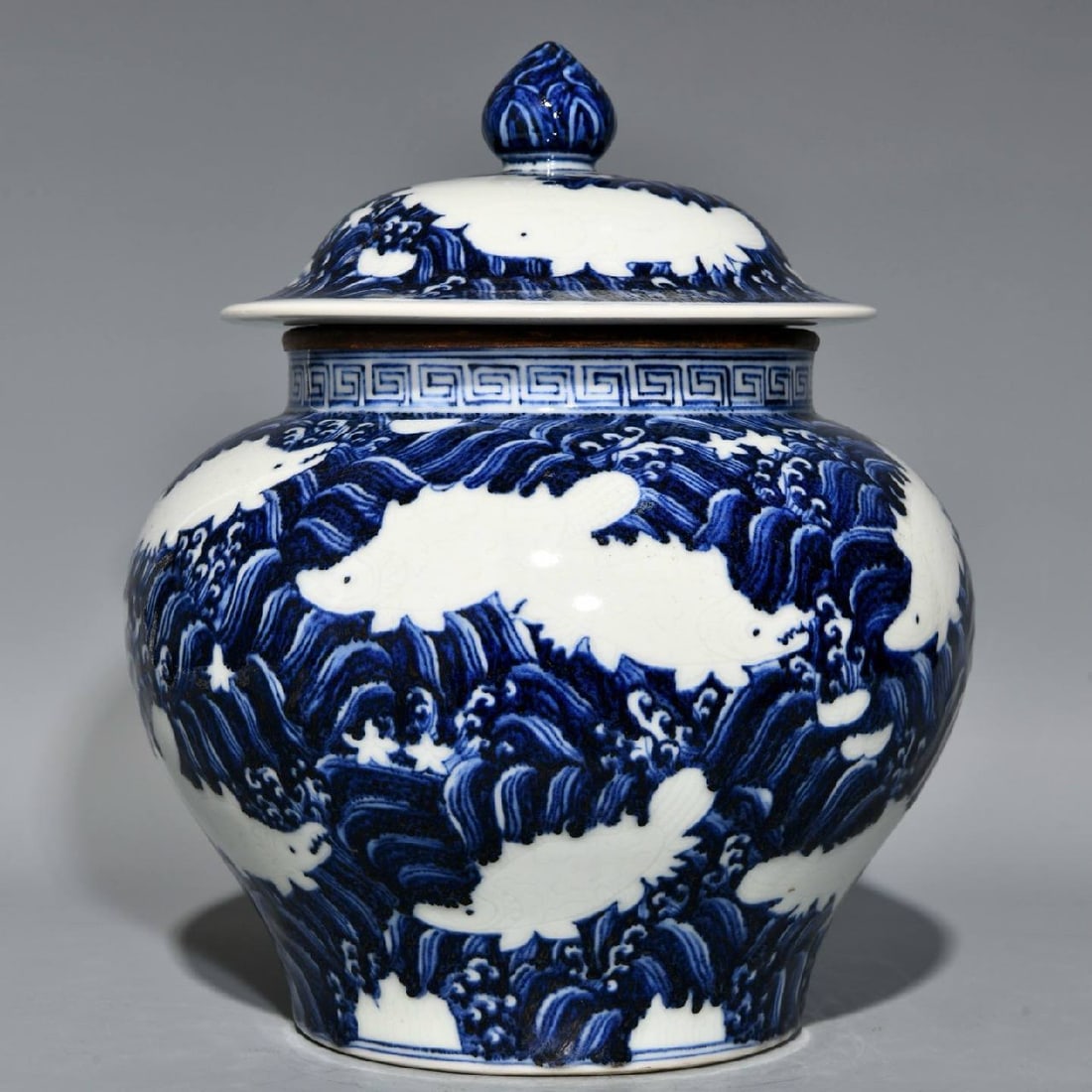 A Ming dynasty jar: A Ming dynasty blue-and-white porcelain covered jar with a design of sea creatures and waves, measuring 27cm in height and 23.5cm in diameter.