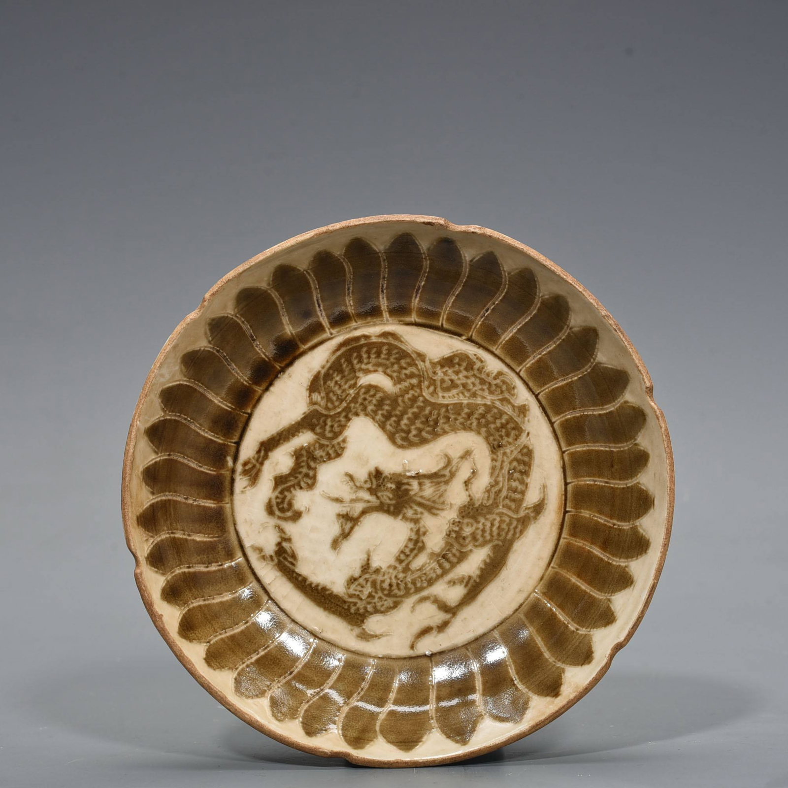 A Song Dynasty Ding dish: A Song Dynasty Ding ware brown-painted dragon-patterned sunflower-shaped dish with an inscribed mark on the base. 3 x 16.5 cm