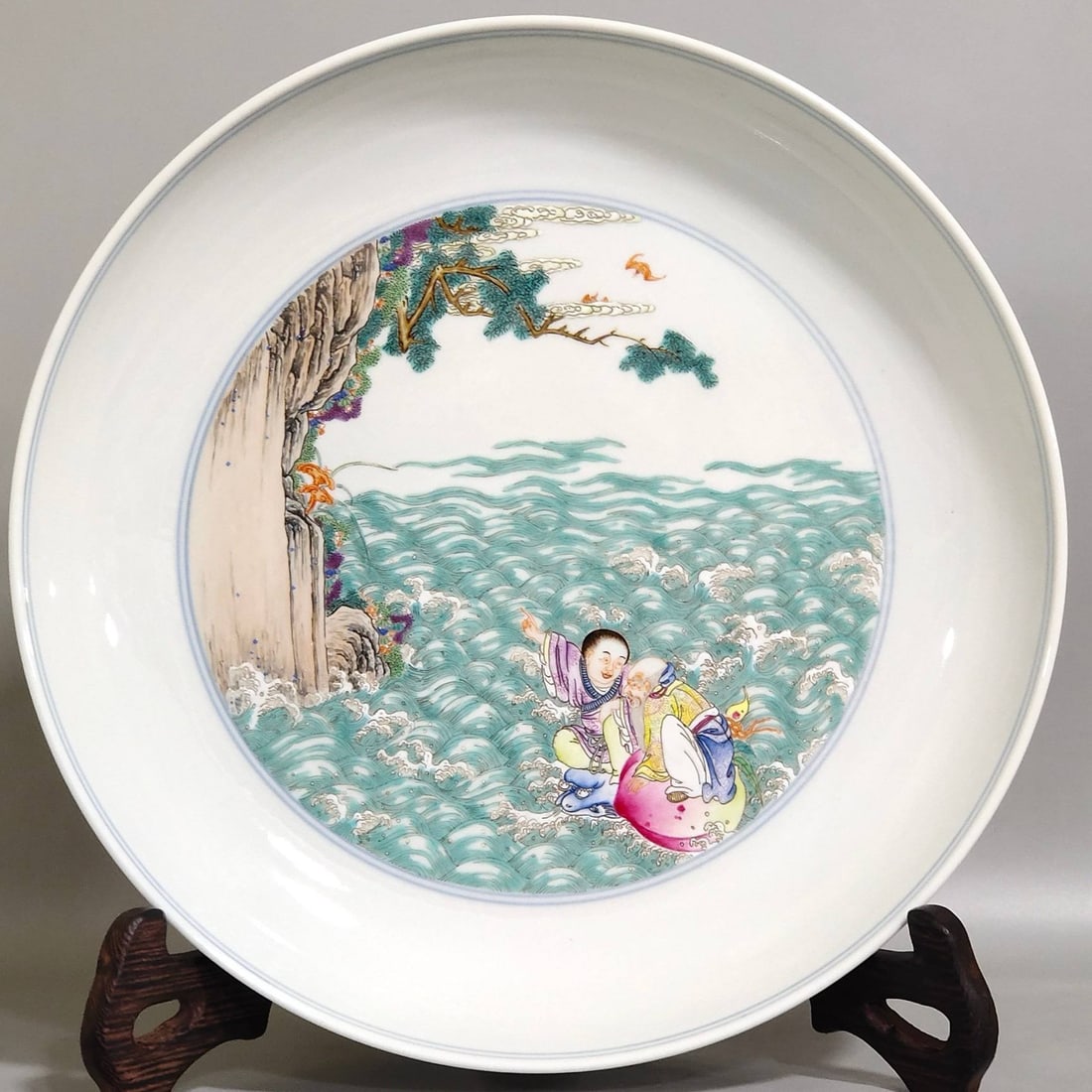 A Qing Dynasty Yongzheng period lotus flower and figure story: A Qing Dynasty Yongzheng period lotus flower and figure story longevity plate, 4.5 cm high and 24 cm in diameter.