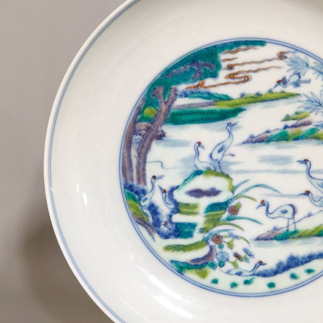 A Qing Dynasty Yongzheng period plate: A Qing Dynasty Yongzheng period Doucai (enamel overglaze enamel) plate depicting pine trees and cranes symbolizing longevity, measuring 3.4 cm in height and 18.1 cm in diameter.