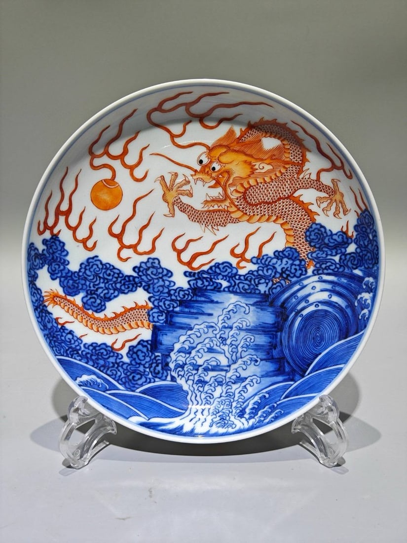 A blue and white porcelain dish with a dragon and sea wave design: A blue and white porcelain dish with a dragon and sea wave design, made during the Kangxi reign of the Qing Dynasty, with a diameter of 20.7 cm.