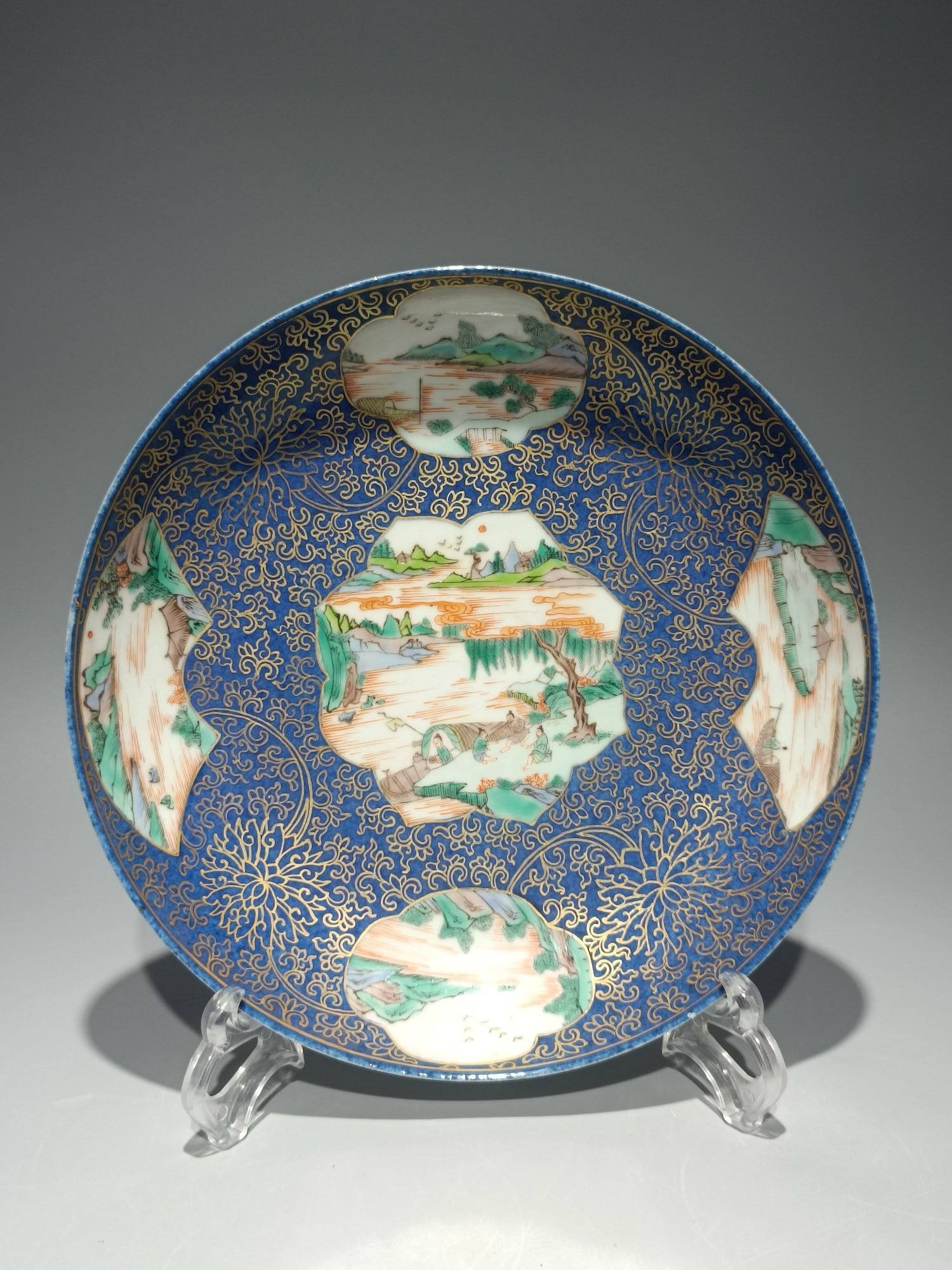 A Qing Dynasty Kangxi period snowflake-blue lacquered plate: A Qing Dynasty Kangxi period snowflake-blue lacquered plate with openwork windows and polychrome figures and landscapes. Diameter: 21.5cm