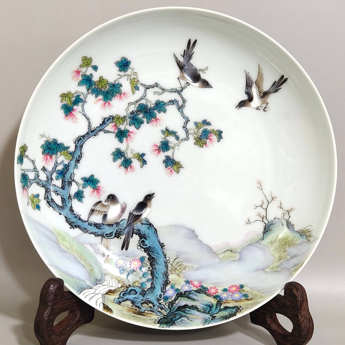 A famille rose flower and bird plate: A famille rose flower and bird plate made by the Caixiu Hall during the Qianlong period of the Qing dynasty, measuring 3.4 cm in height and 16.2 cm in diameter.