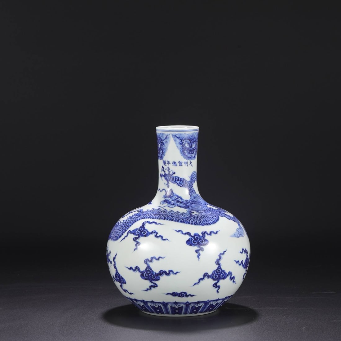 a large blue-and-white porcelain vase: a large blue-and-white porcelain vase from the Xuande period of the Ming dynasty, featuring a design of taotie dragons amidst clouds. Dimensions: Height 29 cm, Mouth diameter 6.5 cm, Belly diameter 22