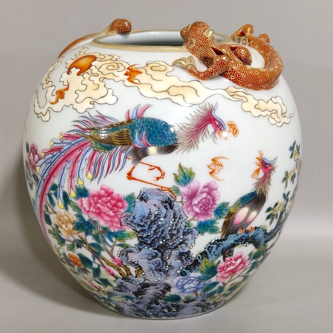A Qing Dynasty Qianlong-era water basin inscribed: A Qing Dynasty Qianlong-era water basin inscribed with a poem on a phoenix and peony design, depicting a coiled dragon and bat motif. It measures 14 cm in height and 12.5 cm in diameter.