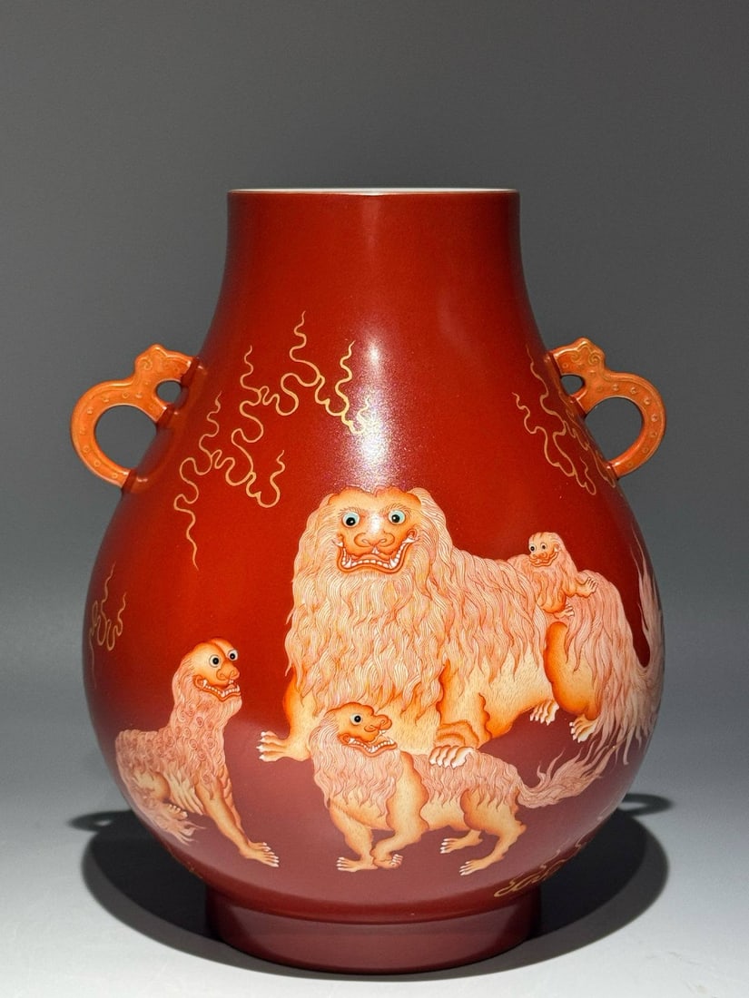 A Qing Dynasty Yongzheng period (1736-1765) coral-red ground vase: A Qing Dynasty Yongzheng period (1736-1765) coral-red ground vase with vanadium-red enamel depicting a lion and a young prince, double-eared and blessed. Height: 26cm Width: 20cm