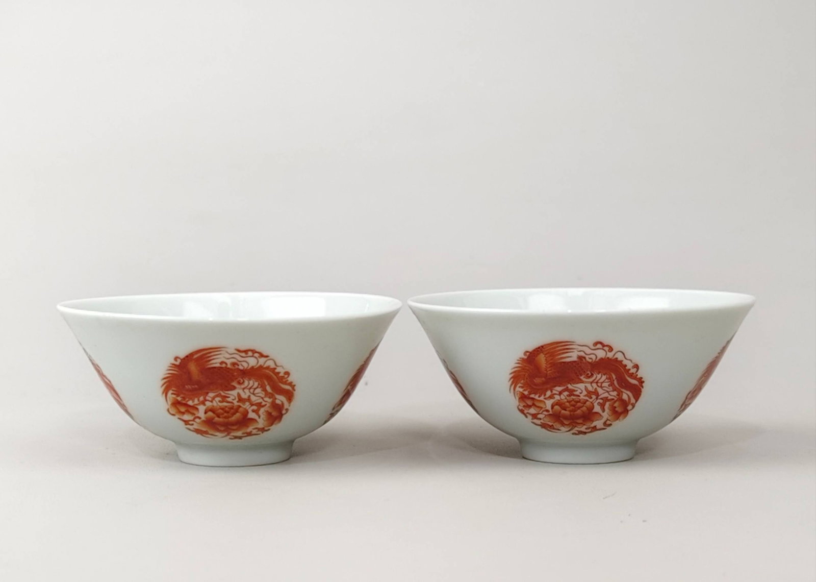 A bamboo-shaped cup with a phoenix design in iron-red enamel: A bamboo-shaped cup with a phoenix design in iron-red enamel, made during the reign of Emperor Yongzheng of the Qing Dynasty. It measures 4.2 cm in height and 9.2 cm in diameter.