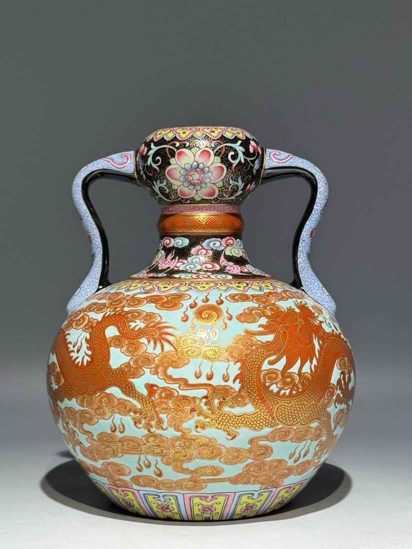 A Qing Dynasty Qianlong period enamel vase: A Qing Dynasty Qianlong period enamel vase with vanadium red and gold decoration depicting dragons, clouds, and auspicious symbols. Height: 22.2cm Width: 18cm