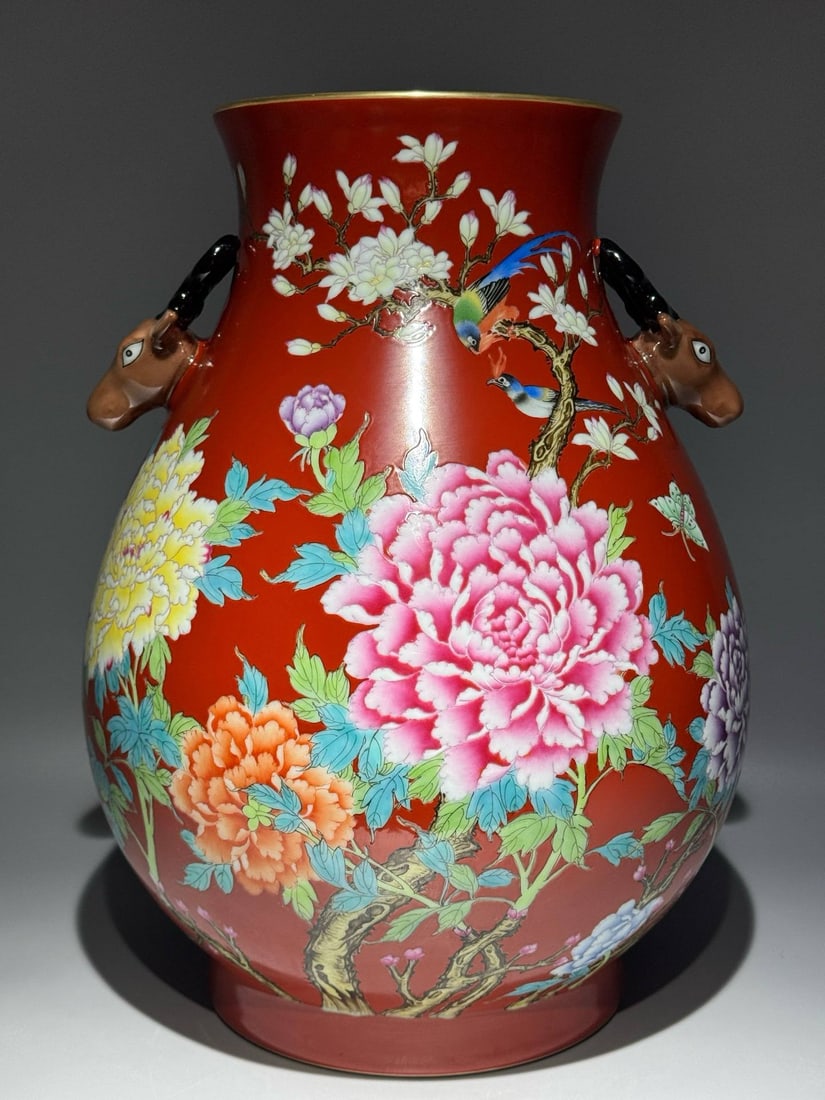 A famille rose vase with a deer head design: A famille rose vase with a deer head design and floral and bird motifs on a coral-red ground, bearing the mark of the Qianlong period of the Qing dynasty. Height: 40.8cm Width: 30cm