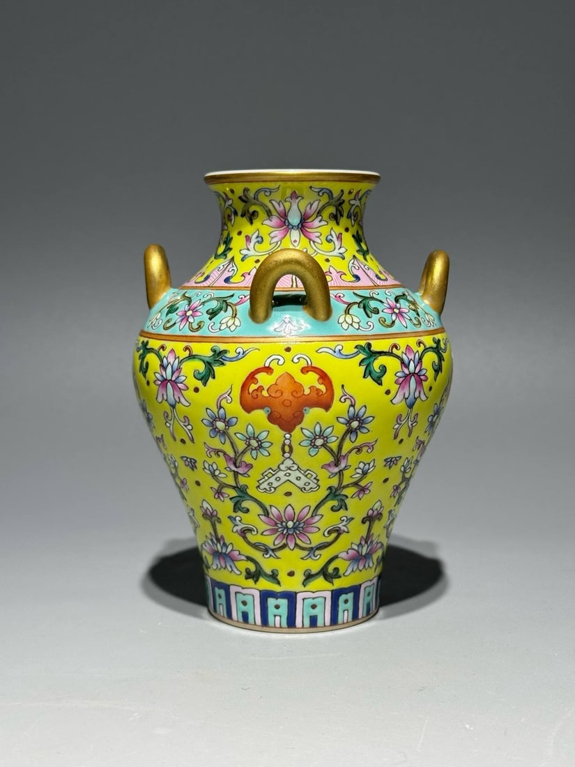 A Qing Dynasty Qianlong period famille rose enamel vase: A Qing Dynasty Qianlong period famille rose enamel vase with a yellow ground and gold-painted frosting depicting auspicious symbols, measuring 11.8 cm in height and 8.8 cm in diameter at the belly.