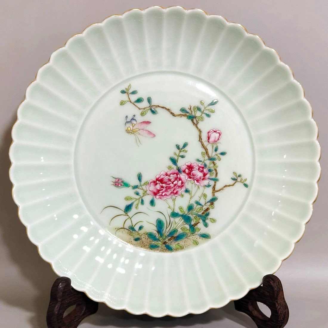 A celadon-glazed chrysanthemum dish with floral and butterfly design: A celadon-glazed chrysanthemum dish with floral and butterfly design from the Qianlong period of the Qing dynasty, measuring 3.2 cm in height and 18 cm in diameter.