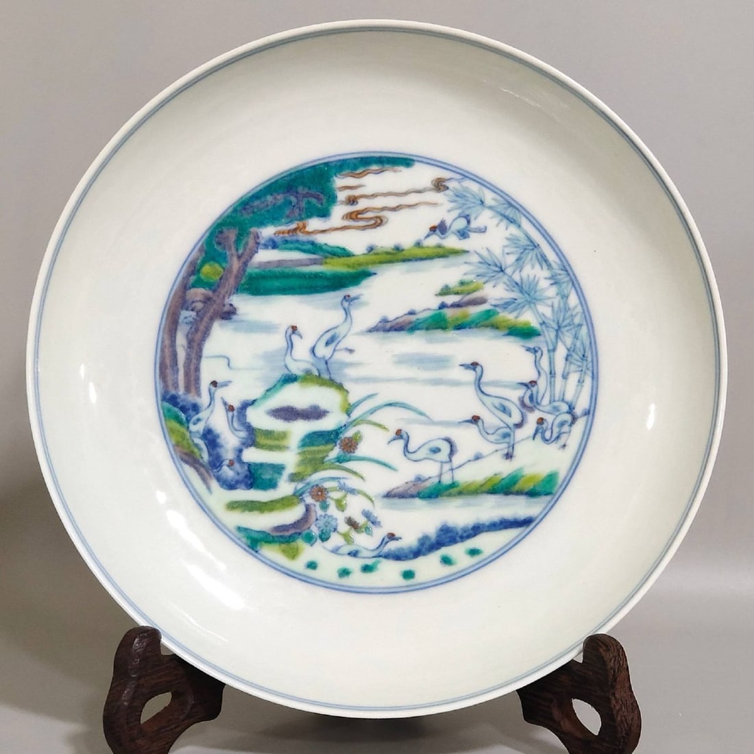 A Qing Dynasty Yongzheng period Doucai (enamel overglaze enamel) plate: A Qing Dynasty Yongzheng period Doucai (enamel overglaze enamel) plate depicting pine trees and cranes symbolizing longevity, measuring 3.4 cm in height and 18.1 cm in diameter.