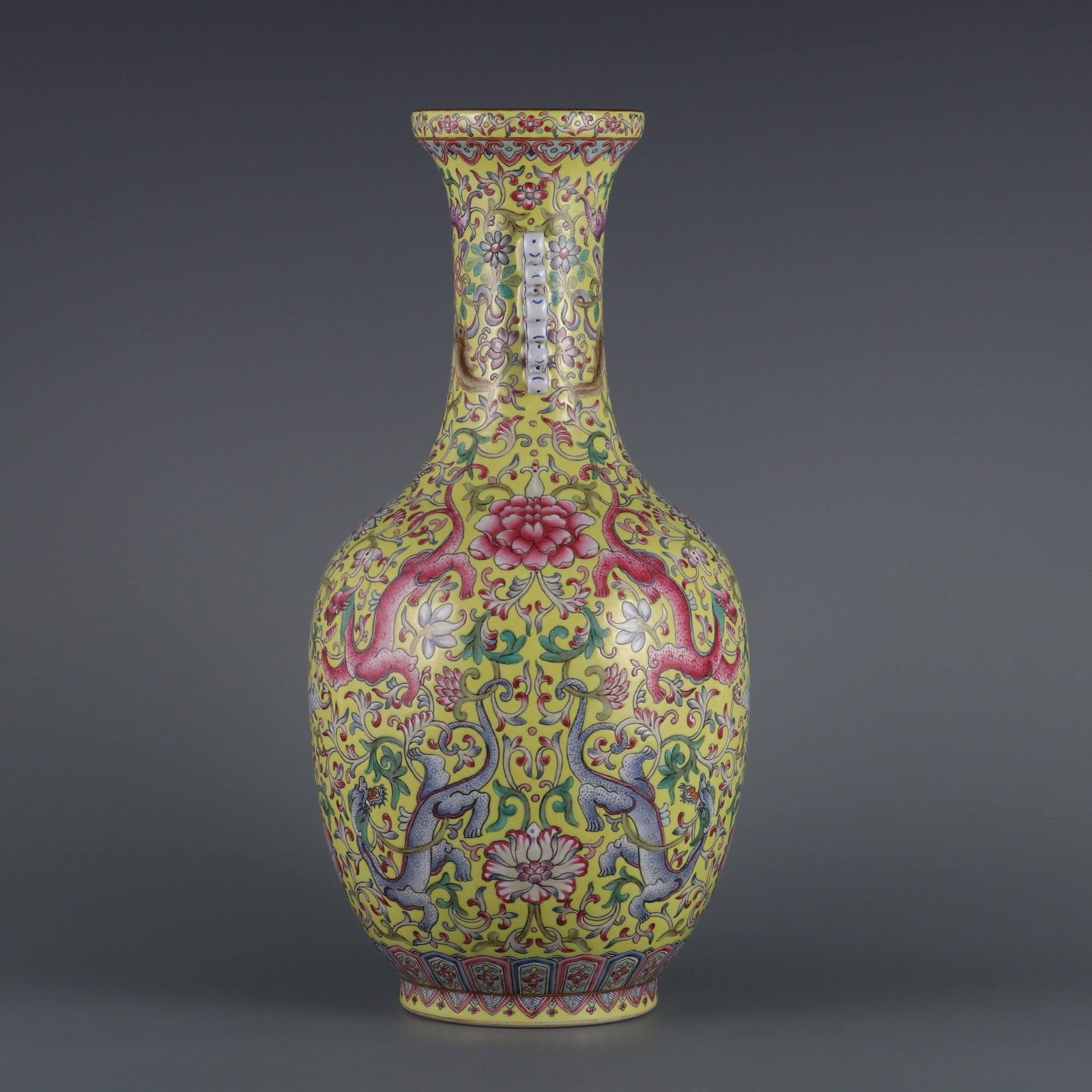 A Qing Dynasty Qianlong period (1736-1745) yellow-ground famille rose vase: A Qing Dynasty Qianlong period (1736-1745) yellow-ground famille rose vase with red dragons and flowers and two handles. Dimensions: Height 34.5 cm, Mouth diameter 8.5 cm, Belly diameter 18 cm.