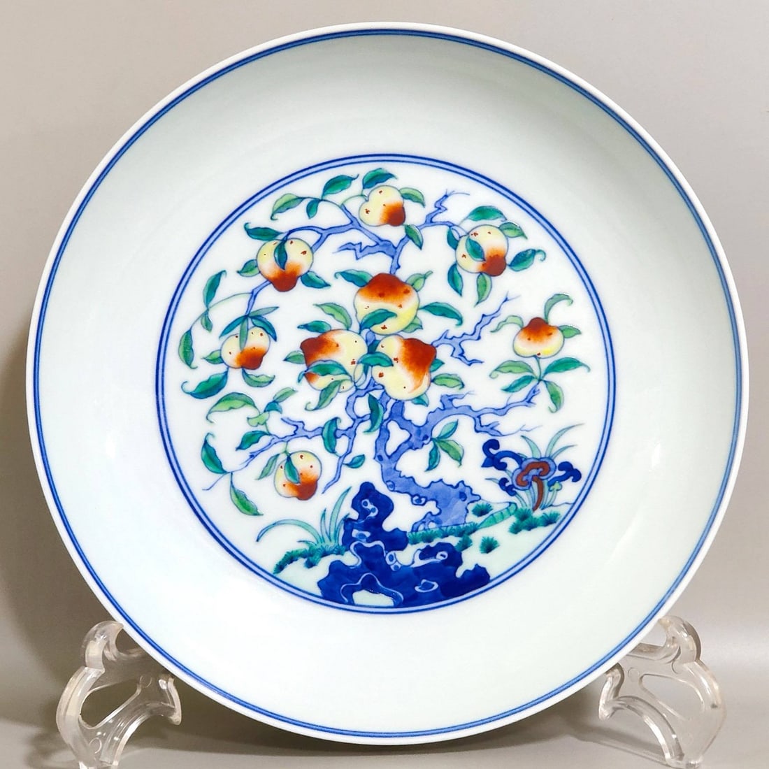 A Qing Dynasty Yongzheng period doucai (enamel overglaze enamel) plate: A Qing Dynasty Yongzheng period doucai (enamel overglaze enamel) plate with cranes and peaches, 3.6 cm high and 20 cm in diameter.
