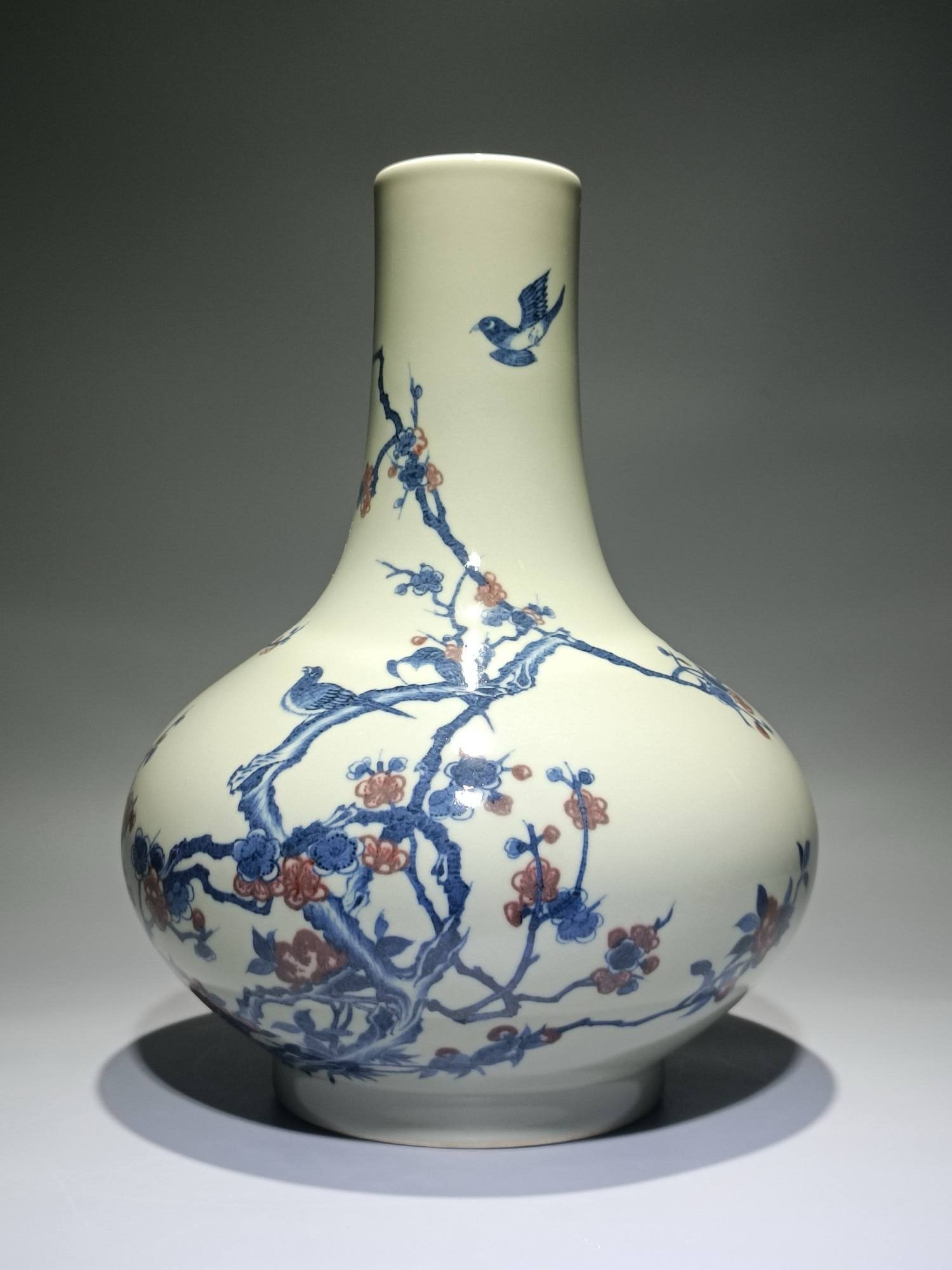 A celadon-glazed, blue-and-white, underglaze red vase: A celadon-glazed, blue-and-white, underglaze red vase with magpies perched on plum blossoms and water chestnuts, bearing the mark of the Guangxu period of the Qing dynasty. Height: 33cm, Width: 25cm