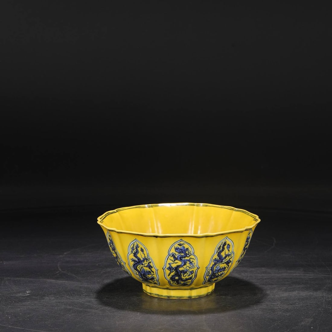 a large, deep-bodied melon-shaped bowl: a large, deep-bodied melon-shaped bowl with a yellow ground and blue-and-white design featuring dragons and openwork patterns, dating from the Yongle period of the Ming dynasty. Dimensions: Height 9 c