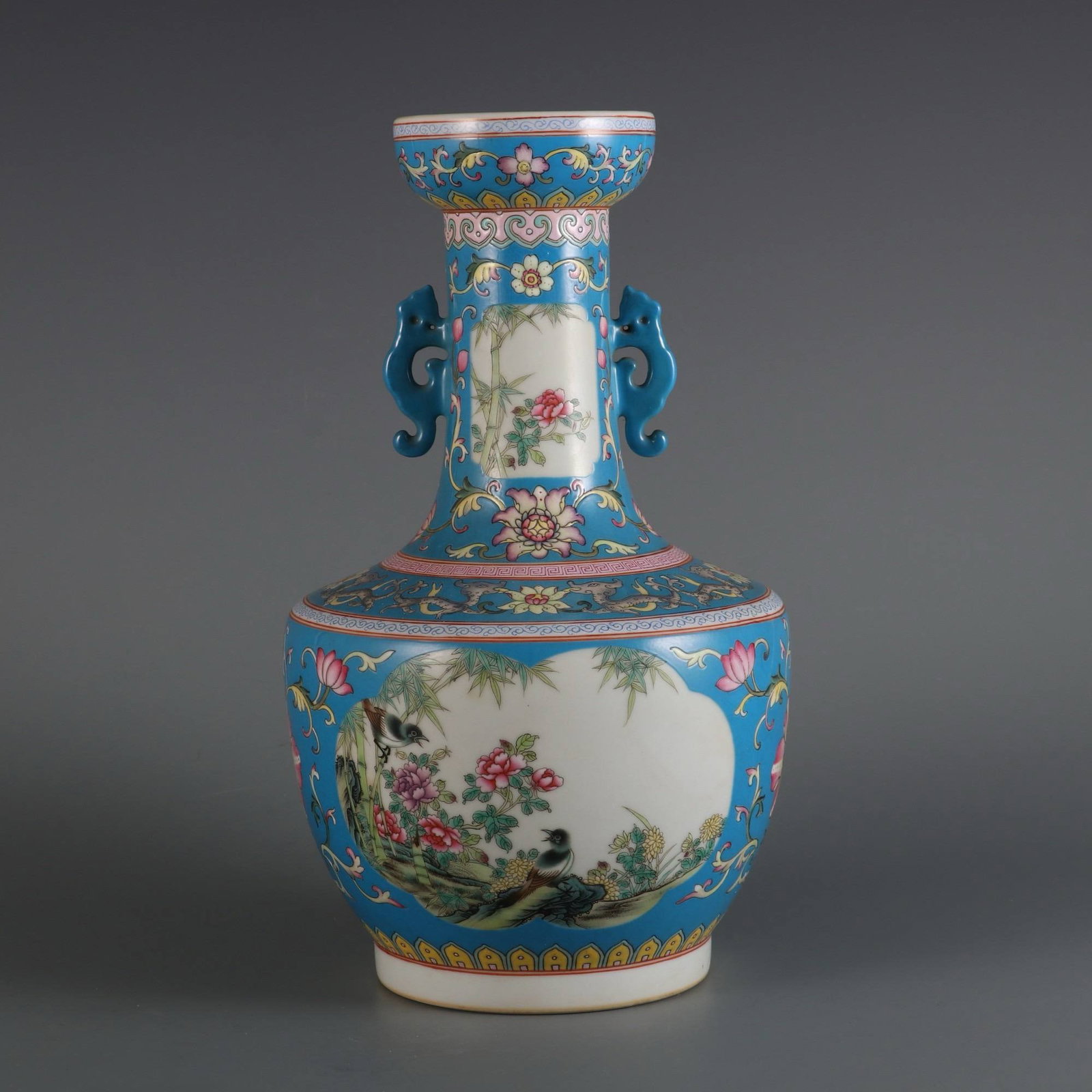 A blue-ground famille rose vase: A blue-ground famille rose vase with bamboo and sparrow design and two handles, made during the Yongzheng period of the Qing dynasty. Dimensions: Height 29.8 cm, Belly diameter 16.5 cm, Mouth diameter