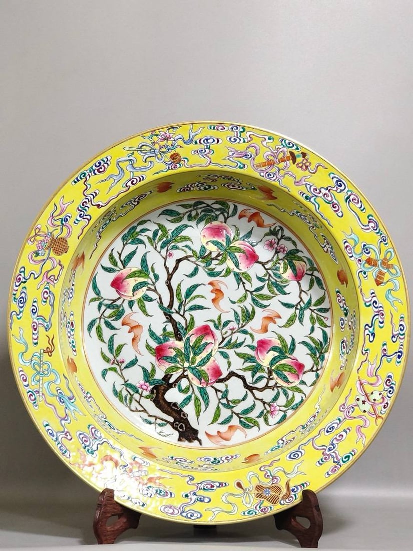 A Qing Dynasty Qianlong period yellow-glazed washbasin: A Qing Dynasty Qianlong period yellow-glazed washbasin with auspicious motifs of good fortune and longevity, 9.5 cm high and 40.5 cm in diameter.