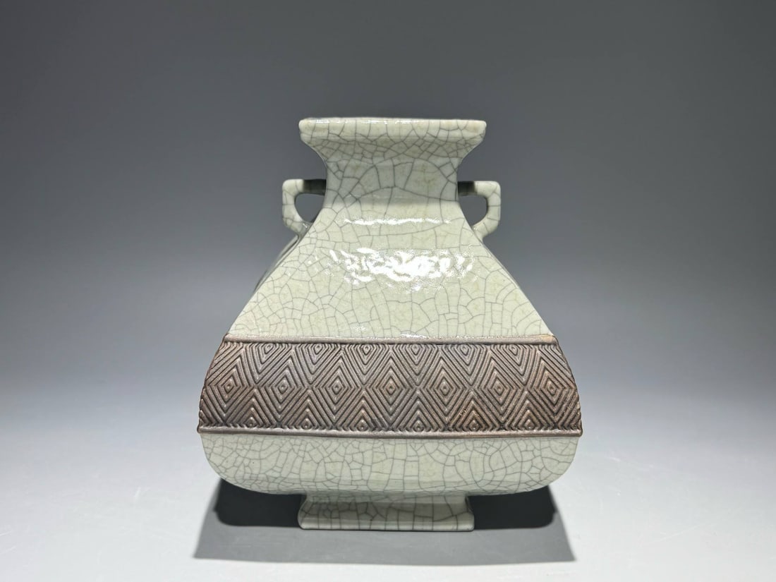 A square vase with carved fretwork handles: A square vase with carved fretwork handles and a Qianlong mark from the Qing dynasty. Height: 19.8cm, Width: 16cm
