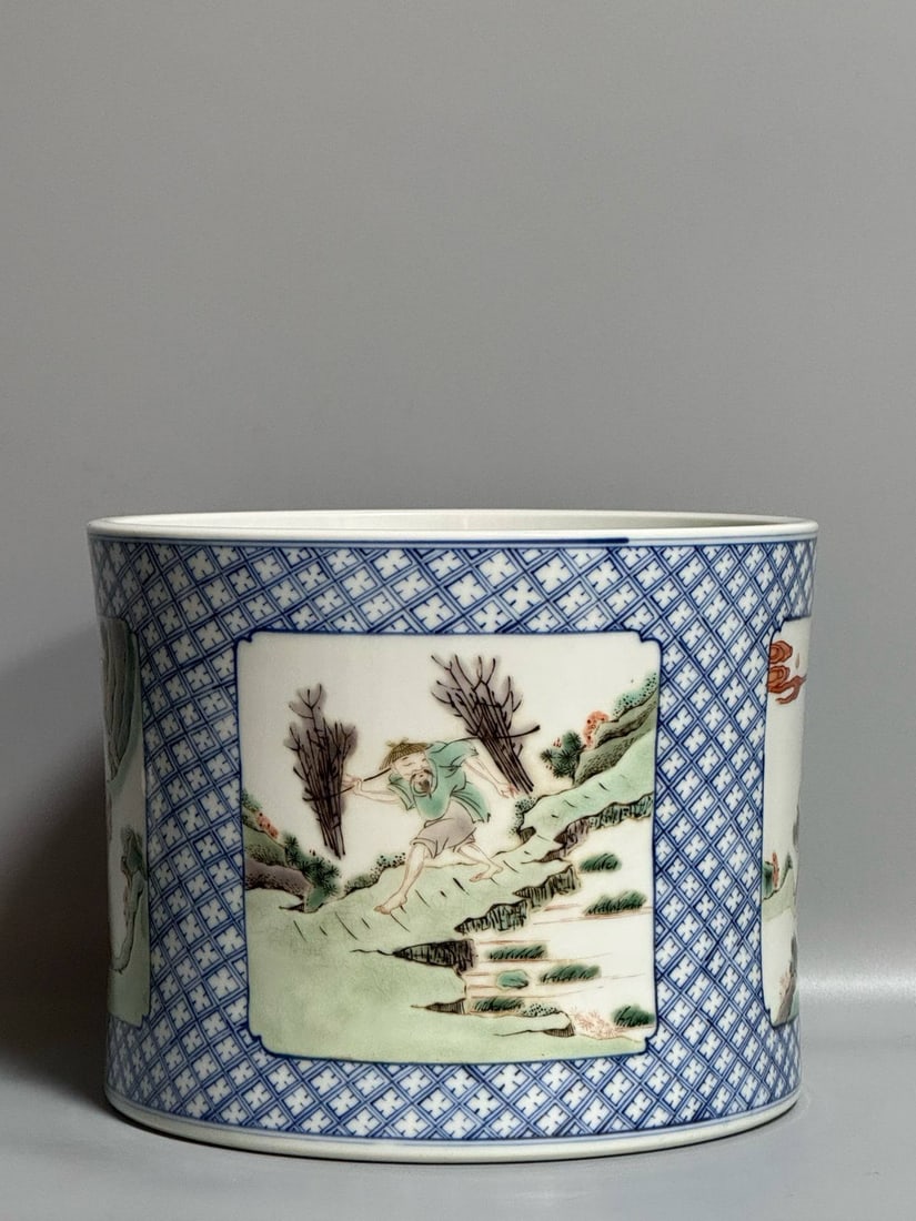 A polychrome brush pot depicting figures and scenes from the Kangxi period: A polychrome brush pot depicting figures and scenes from the Kangxi period of the Qing Dynasty, 15.5 cm high and 19.5 cm in diameter.