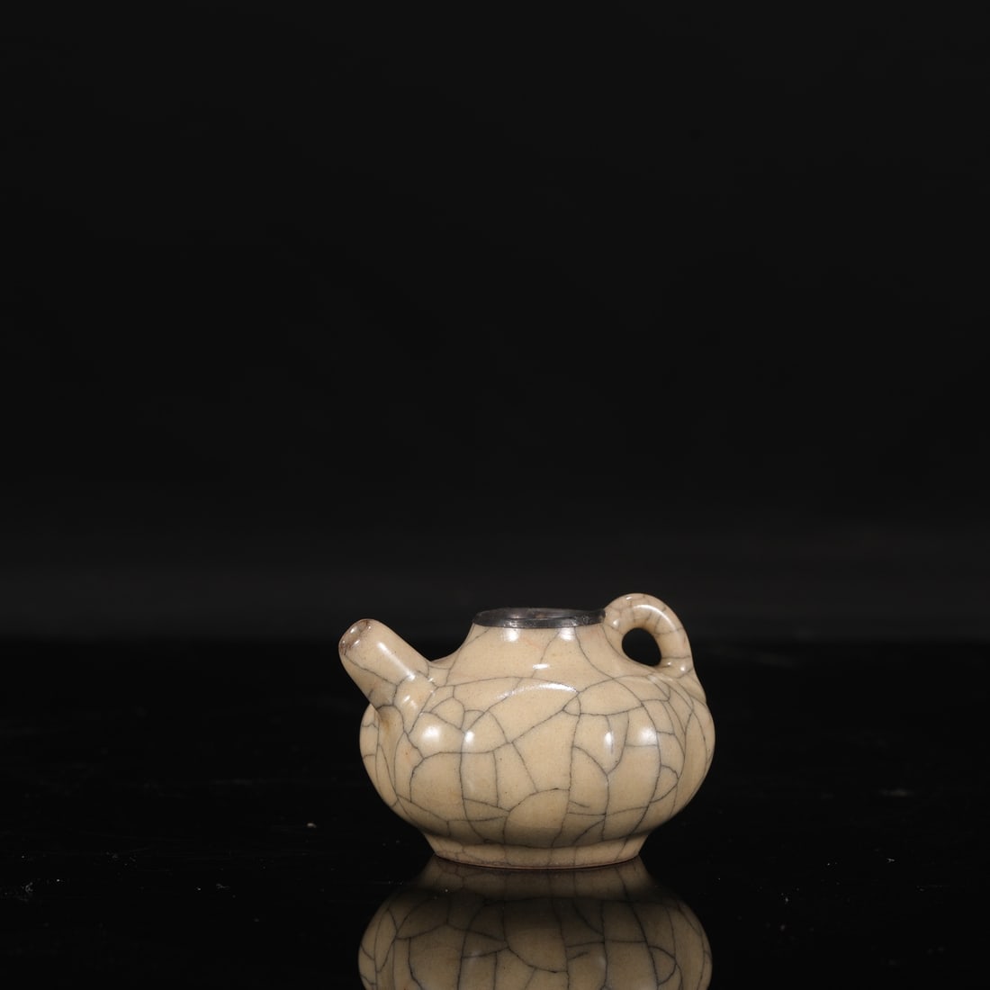 A Northern Song Dynasty Ge ware teapot with a beige glaze and silver rim, from a collection, bearing: Dimensions: Height 6 cm, Mouth diameter 2.8 cm, Belly diameter 7 cm.