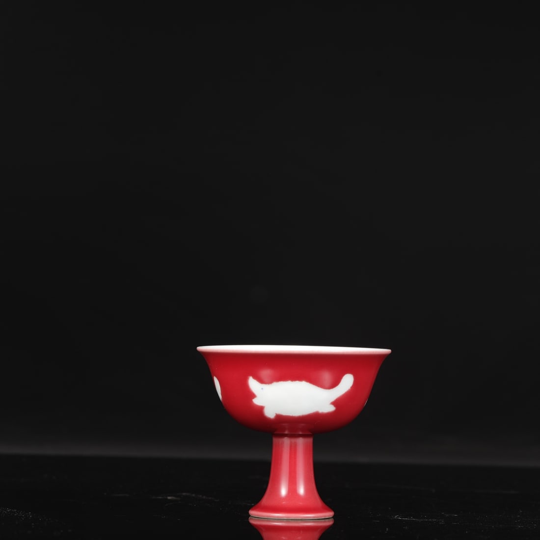 A Ming Dynasty Xuande period gem-red glazed stem cup with fish design, formerly in the collection. (1 of 8)