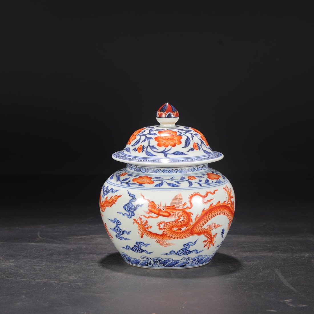 A large covered jar with blue and white porcelain and iron-red sea and cloud dragon design from the: Height: 21 cm, Mouth diameter: 10 cm, Belly diameter: 16.5 cm