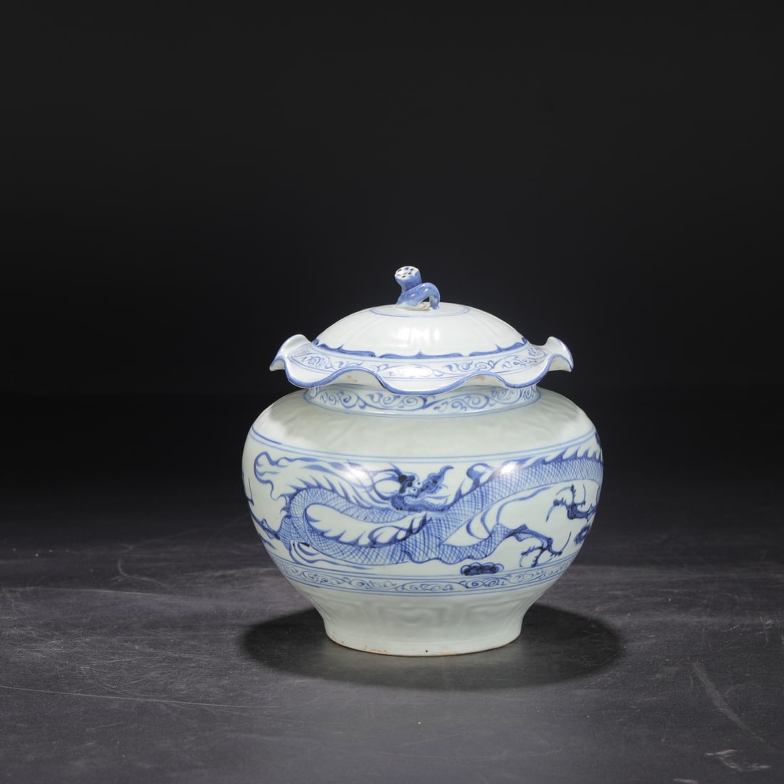 A Yuan Dynasty blue and white porcelain jar with a lotus leaf design and cloud and dragon motif,: Height: 20.5 cm, Mouth diameter: 12 cm, Belly diameter: 18 cm