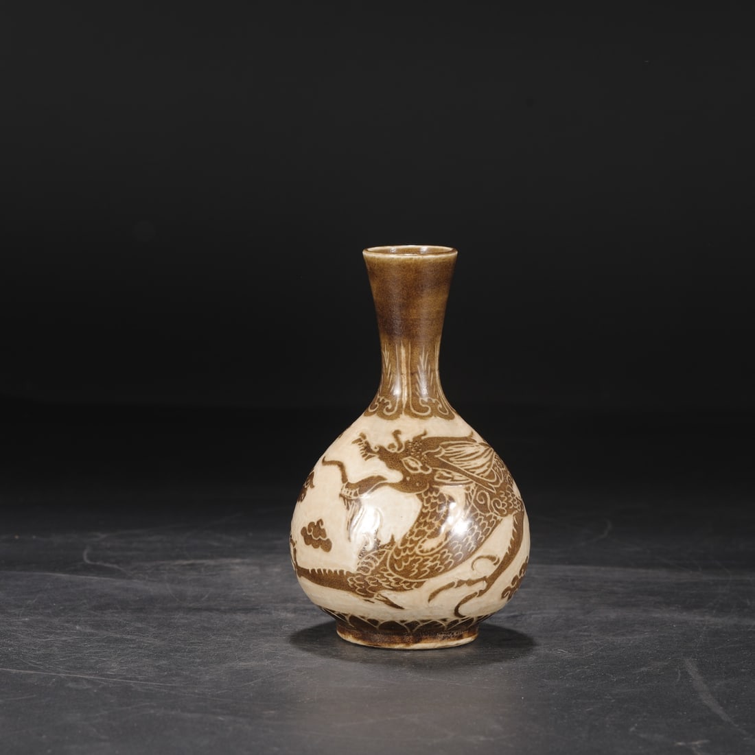 A Northern Song Dynasty Ding ware vase with brown-painted carved cloud and dragon design, formerly: Dimensions: Height 18.5 cm, Mouth diameter 4.5 cm, Belly diameter 10 cm.