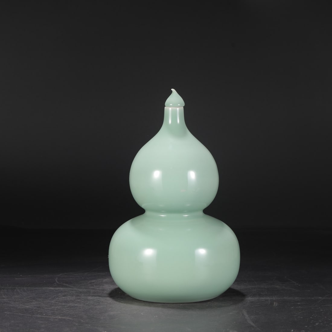 A large celadon gourd-shaped vase from the Yongzheng period of the Qing dynasty, formerly in the: Dimensions: Height 34.5 cm, Mouth diameter 3 cm, Belly diameter 20 cm.