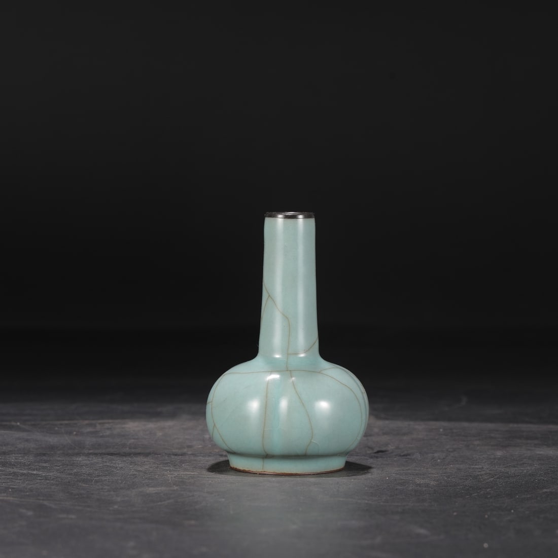 A Southern Song Dynasty official kiln celadon vase with a silver mouth and straight neck, formerly: Dimensions: Height 13 cm, Mouth diameter 2.5 cm, Belly diameter 7.5 cm.