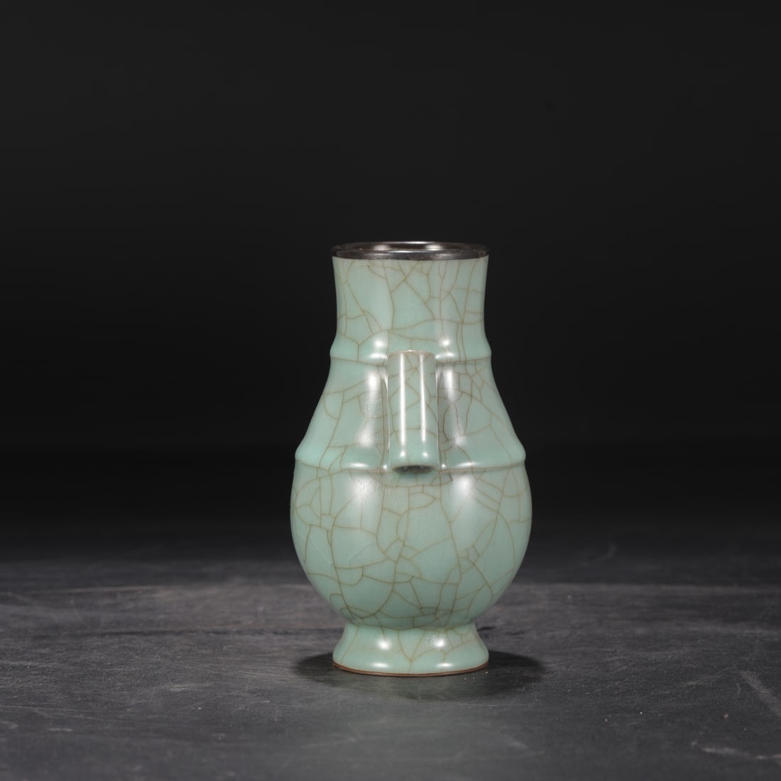 A Southern Song Dynasty official kiln celadon vase with silver rim and tubular handles, formerly in: Dimensions: Height 16 cm, Mouth diameter 7 cm, Belly diameter 10 cm.