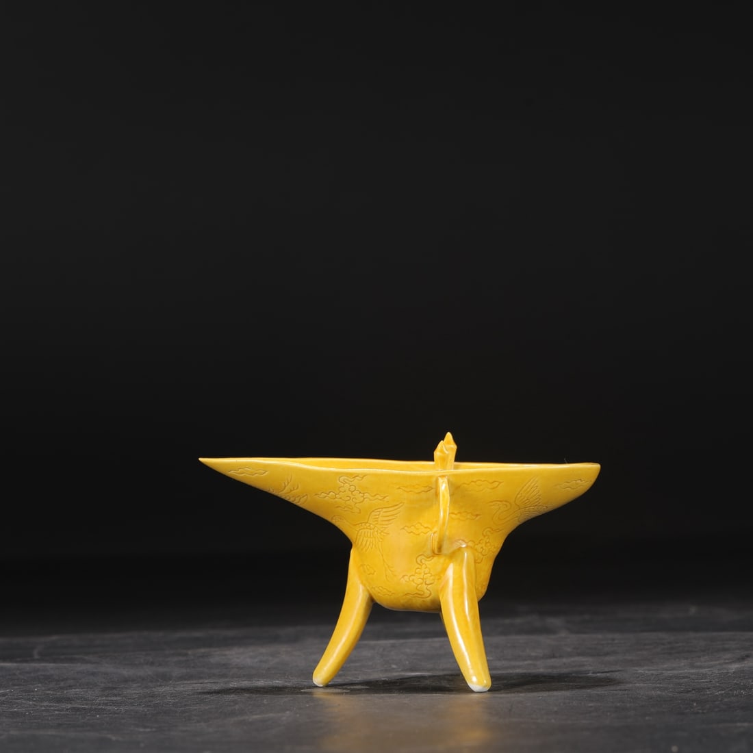 A Ming Dynasty Hongzhi period pale yellow glazed wine cup with incised cloud and crane design.: Dimensions: Height 9 cm, Mouth diameter 14.5 cm.
