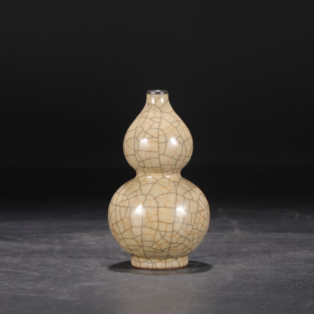 A Northern Song Dynasty Ge ware gourd-shaped vase with a beige glaze and silver mouth, formerly from: Dimensions: Height 14 cm, Mouth diameter 1.5 cm, Belly diameter 7.5 cm.