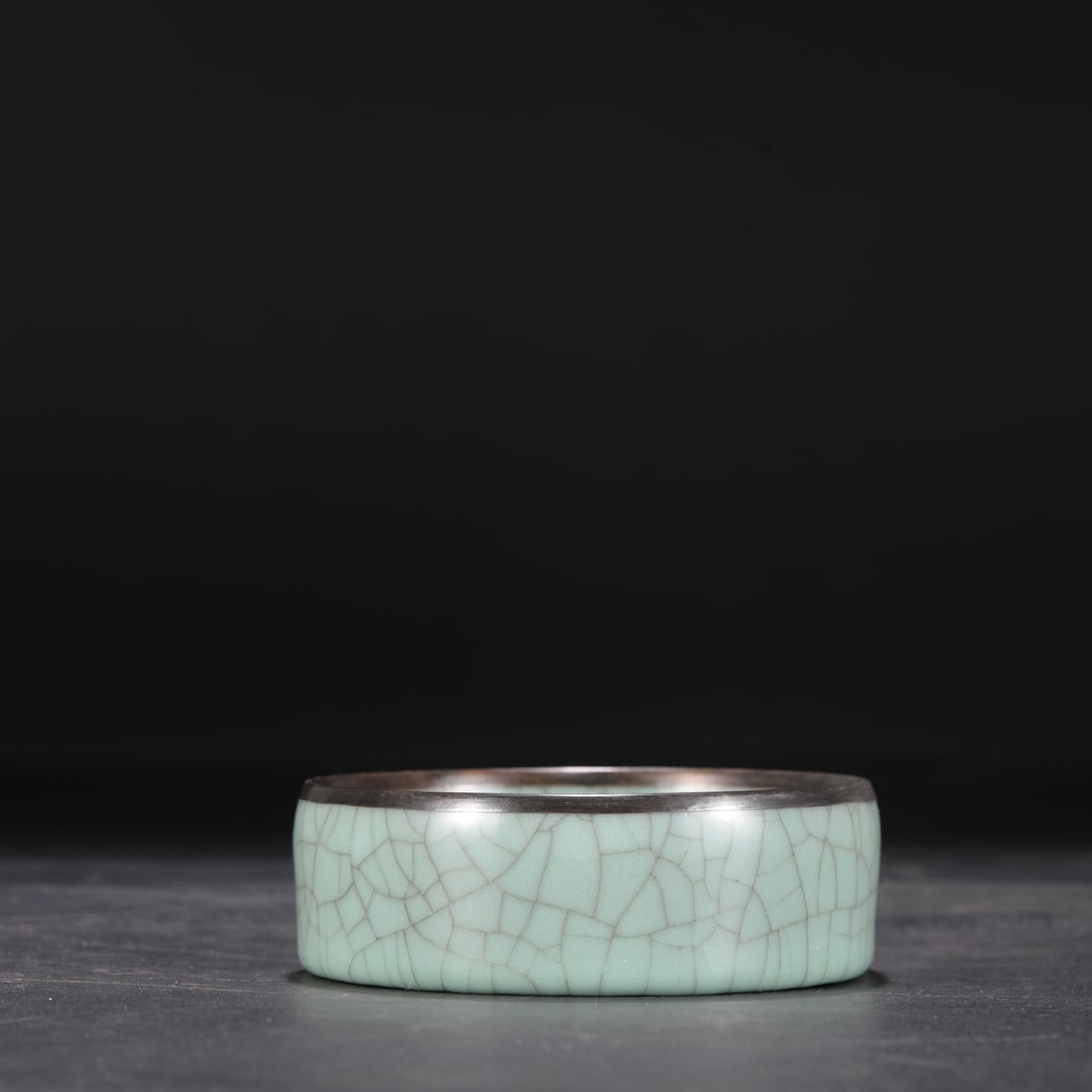 A large, round, celadon-glazed washer with a silver rim, formerly in the collection of the Southern: Dimensions: Height 4 cm, Diameter 12 cm.