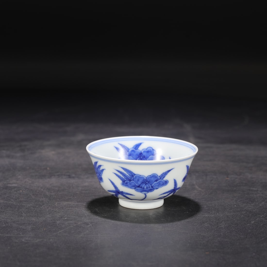 The Ming Dynasty Chenghua blue and white porcelain cup with a scrolling floral design, formerly in: measures 4.5 cm in height and 8.5 cm in diameter.