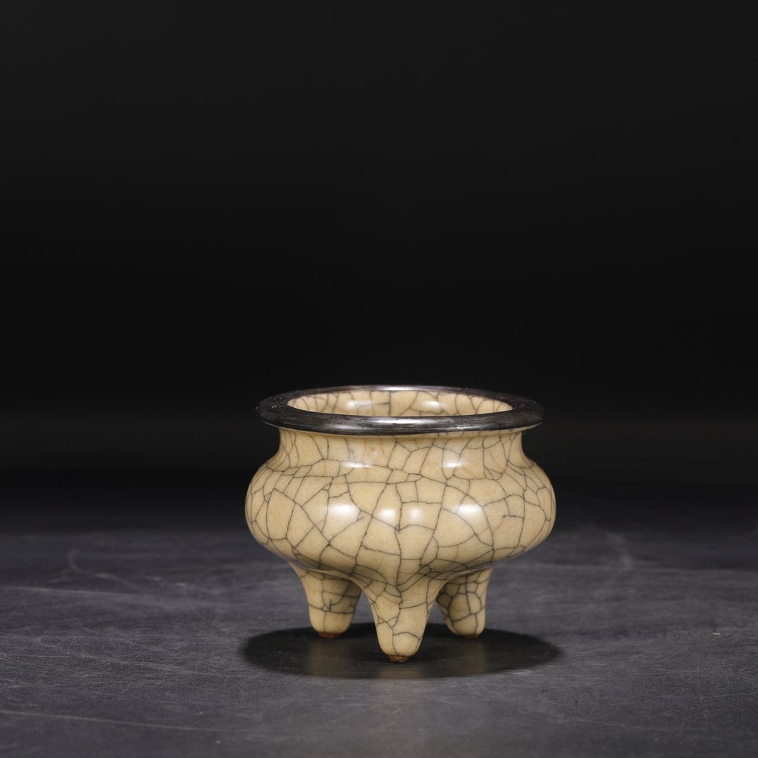 A Northern Song Dynasty Ge ware rice-yellow glazed silver-rimmed tripod censer with the inscription: Dimensions: Height 8 cm, Mouth Diameter 6.5 cm.