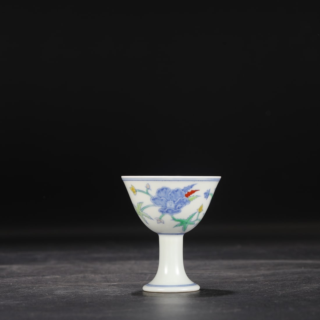 A Ming Dynasty Chenghua period doucai (enamel overglaze) stem cup with a scrolling floral design,: Dimensions: Height 7.8 cm, Mouth Diameter 6.5 cm.