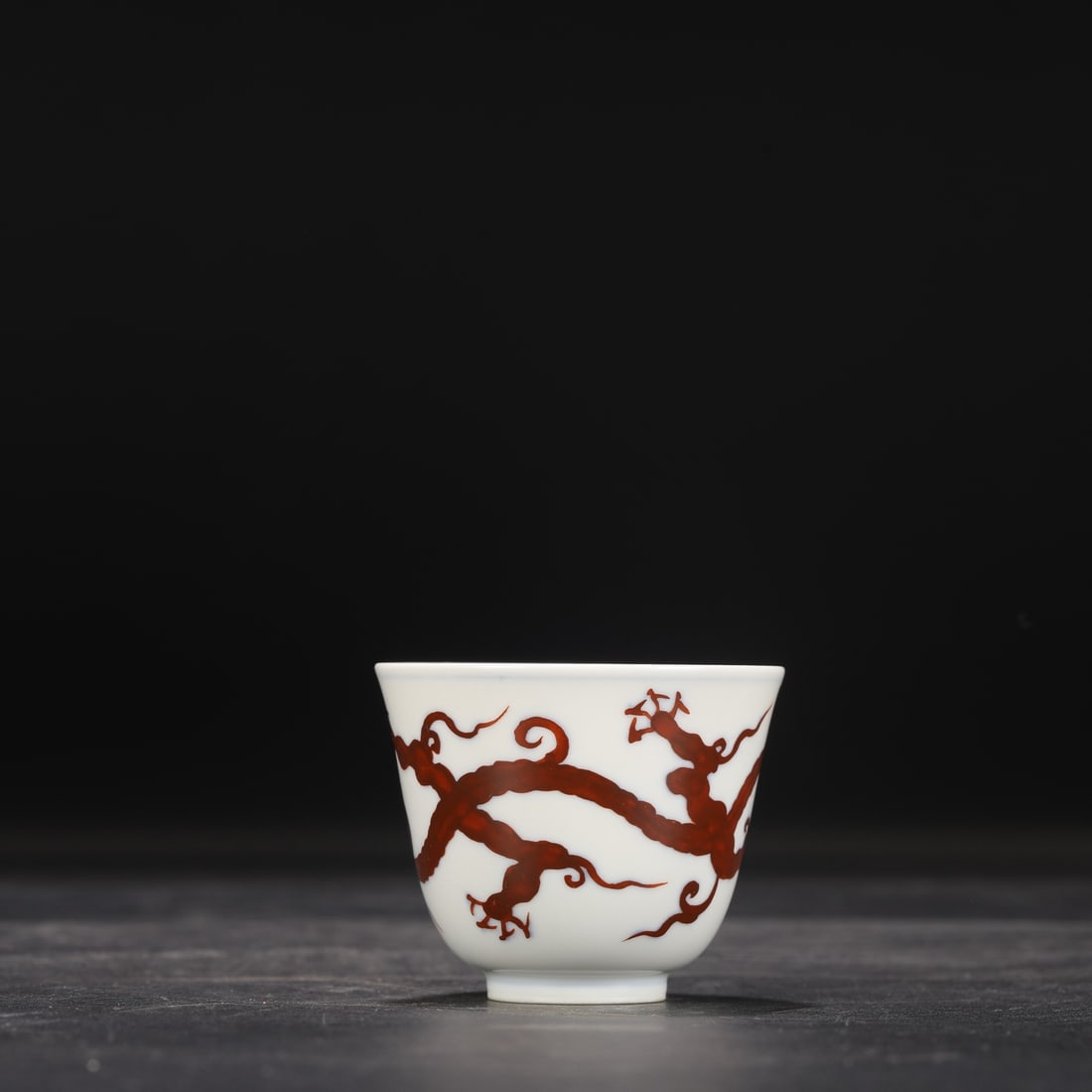 A Ming Dynasty Chenghua period iron-red dragon-patterned bell cup from a collection.: Dimensions: Height 5.3 cm, Mouth diameter 7 cm.