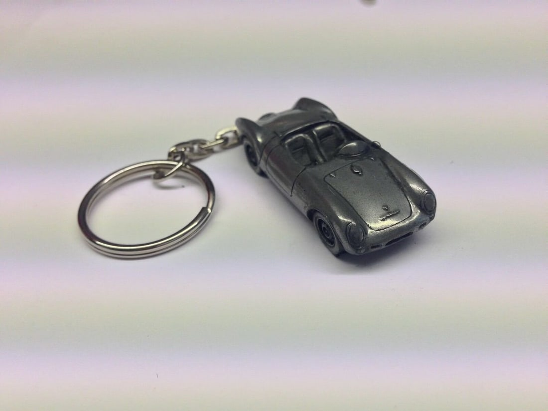 Porsche 550 Spider Keychain: Porsche is a German luxury sports car manufacturer known for producing high-performance vehicles with a focus on precision engineering and design. Here are some key points about Porsche:1. **Founding:
