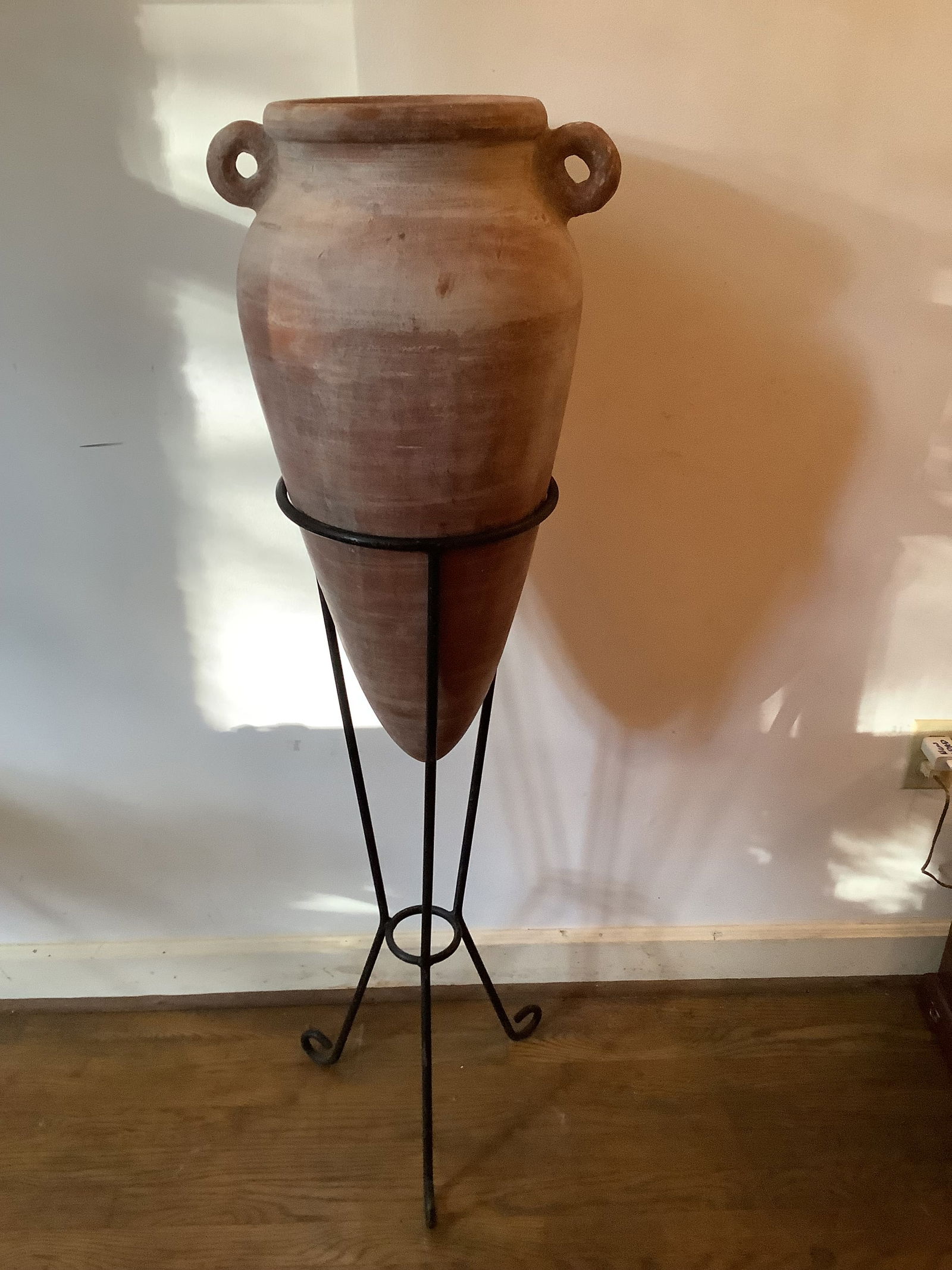 Clay Amphora on Iron Stand: Clay amphora on an iron stand. All in good vintage condition. Measurements: 49” H with stand, pot 27” x 15”.